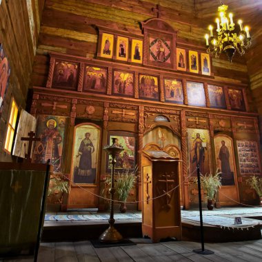 Eski bir ahşap Ortodoks kilise içinin. Rusya, Suzdal. İkonostasisin, Ortodoks simgeler, günlük duvarlar, mumlar. Kırmızı ve sarı renkler doymuş.