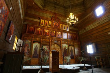 Eski bir ahşap Ortodoks kilise içinin. Rusya, Suzdal. İkonostasisin, Ortodoks simgeler, günlük duvarlar, mumlar. Kırmızı ve sarı renkler doymuş.
