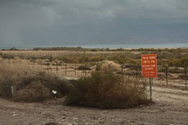 İbranice ve Arapça Yazıt: askeri bölge girmeyin. West Bank, İsrail ve Ürdün, dikenli tel, fırtınalı gökyüzü arasında sınır bölgesi.