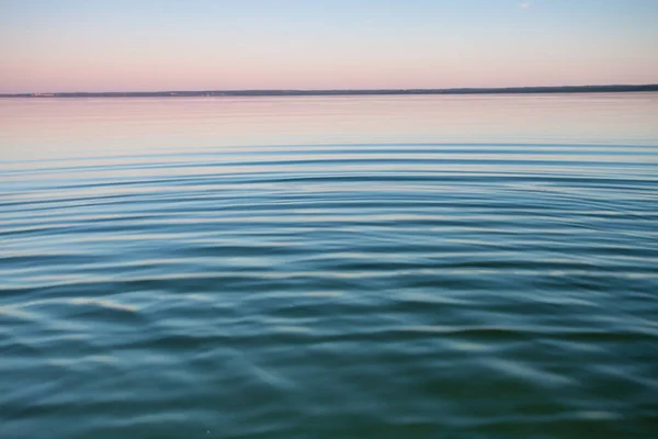黎明时的绿松石湖 在黎明时 蓝色和绿松石湖表面的小对称波浪 红色和橙色和天空蓝色 — 图库照片