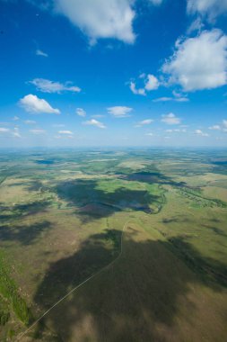 Yolun ve bulutların gölgesi. Havadan görünümü büyük bir yükseklikten. Bulutlar, gölgelerin içinden bulutlar, yol.