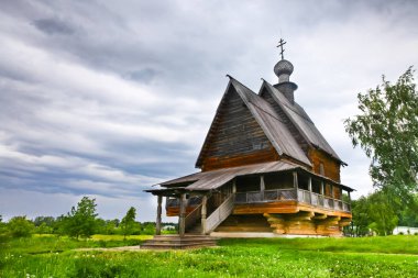 Eski Rus ahşap kilise fırtınalı gökyüzü altında. Eski ahşap kilise üzerinde yeşil ciğeri