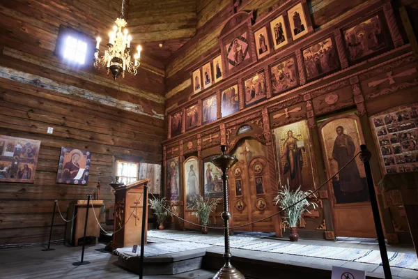 Eski bir ahşap Ortodoks kilise içinin. Rusya, Suzdal. İkonostasisin, Ortodoks simgeler, günlük duvarlar, mumlar. Kırmızı ve sarı renkler doymuş.