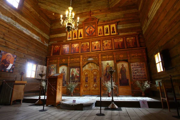 Eski bir ahşap Ortodoks kilise içinin. Rusya, Suzdal. İkonostasisin, Ortodoks simgeler, günlük duvarlar, mumlar. Kırmızı ve sarı renkler doymuş.