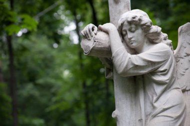 Moskova / Rusya-Temmuz 24, 2018: bir kaç hayatta kalan mezar taşları yas angel bir haç, koyu yeşil yeşillik bir arka plan ile tasvir eden 19. yüzyıl.