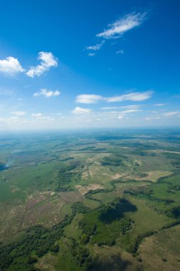 Nehir ve mavi gökyüzü. Havadan görünümü büyük bir yükseklikten. Bulutlar, gölgelerin içinden bulutlar, yol.