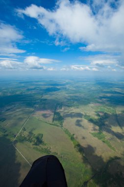 Ne bir yamaçparaşütü görür. Havadan görünümü büyük bir yükseklikten. Bulutlar, gölgelerin içinden bulutlar, yol.