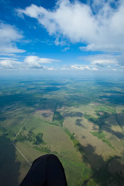 Ne bir yamaçparaşütü görür. Havadan görünümü büyük bir yükseklikten. Bulutlar, gölgelerin içinden bulutlar, yol.