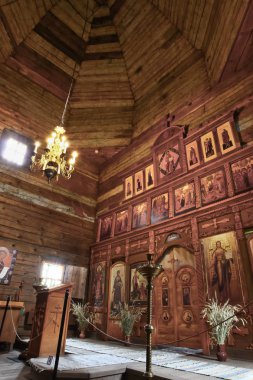 Eski bir ahşap Ortodoks kilise içinin. Rusya, Suzdal. İkonostasisin, Ortodoks simgeler, günlük duvarlar, mumlar. Kırmızı ve sarı renkler doymuş.