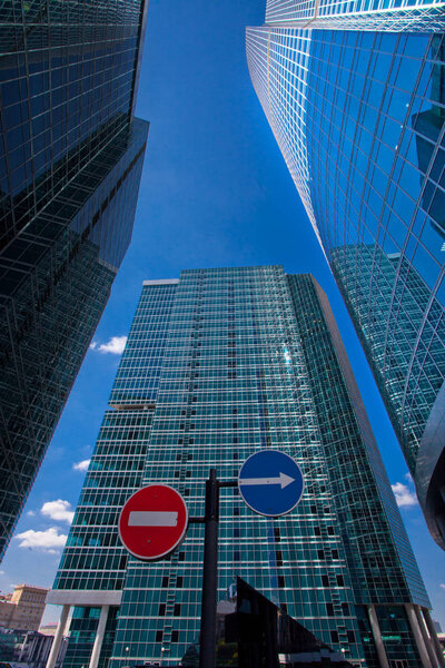 Moscow / August, 2, 2018: Russia- Road signs on the background of skyscrapers in the business center regulate traffic. Sign fare is banned, traffic is straight, a skyscraper is a symbol of road business, a good road and a bad road