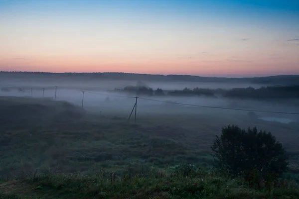 Der Vormorgendliche Dunst Über Der Ländlichen Landschaft Mit Einer Hochspannungsleitung — Stockfoto