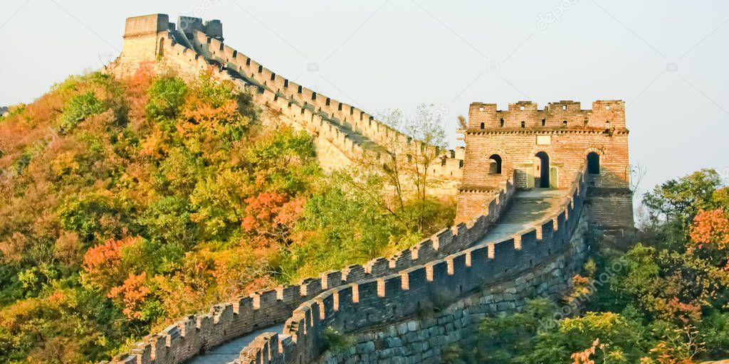 A great Chinese wall among the mountains covered with autumn forest. Plot Mutianyu Great Wall of China