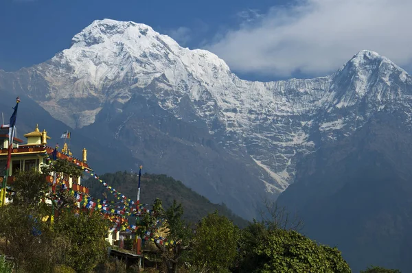 Buddhist monastery and snowy mountains. Trekking to Annapurna Base Camp, Nepal.