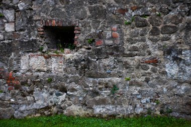 Gri taş ve yeşil çim kaotik döşeme antik karanlık duvarına. arka plan
