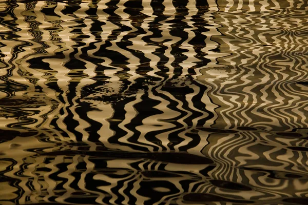Vlny na vodě tvoří pruhy podobné textury vel — Stock fotografie