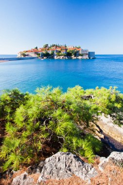 Kırmızı kiremitlerle kaplı eski evler ve parlak mavi deniz, yakın plan. 