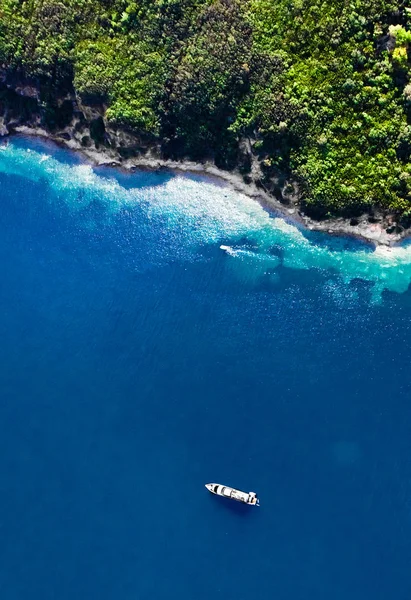 Yeşil ormanlık uçurum (Cennet Adası) ve park etmiş bir yatı var. — Stok fotoğraf