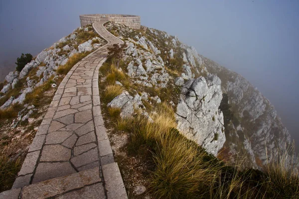 Winding path (road) over a cliff. Everything is in a cloud of fo — Stock Photo, Image