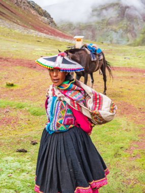 Vinicunca, Peru - 7 Ocak 2017. Vinicuca dağda turistik ulaşım için kullanılan bir at taşıyan bir kadın görünümü.