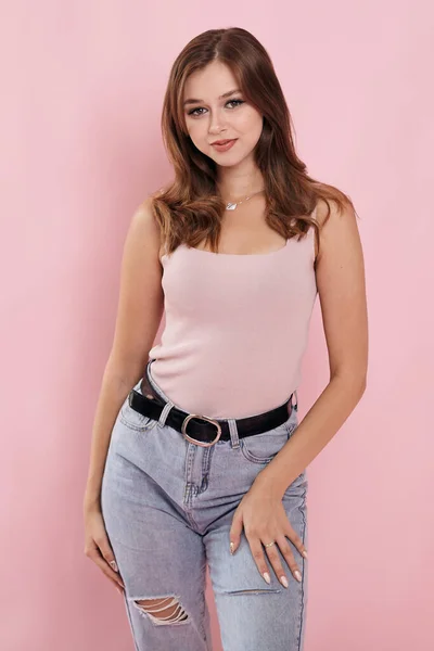 Pembe arka planda kot giyen bir kız.