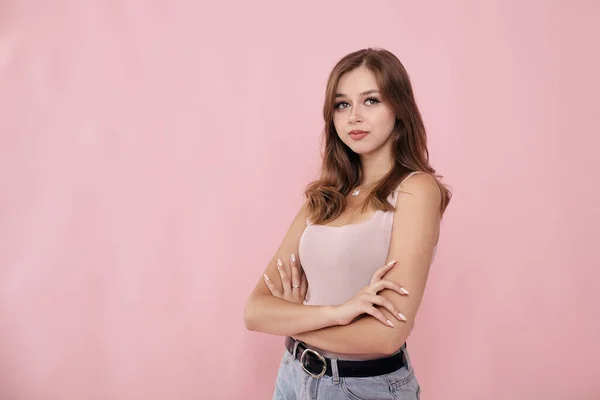 Pembe arka planda pembe tişörtlü bir kız.