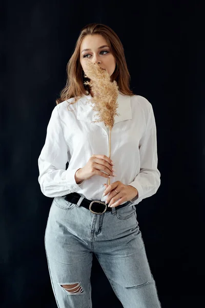 Ellerinde buğday sapı olan beyaz gömlekli kadınlar.