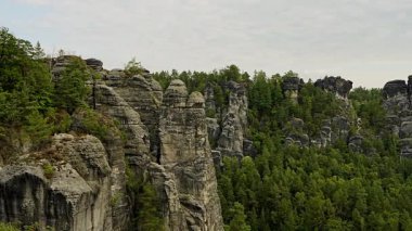 Majestic kumtaşı kayalıkları, Almanya 'nın Sakson İsviçre Ulusal Parkı' ndaki Bastei Köprüsü 'nden görüldüğü gibi manzara boyunca uzanır. Manzara, seyahat, doğa içeriği için harika.