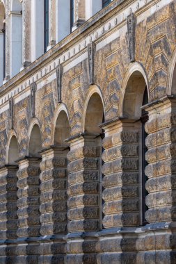 Dekoratif sütunları ve kemerli açıkları olan eski taş duvar. Kültürel, mimari projeler için arkaplan, doku ya da tasarım unsuru kadar mükemmel olan tarihsel mimari ayrıntı.