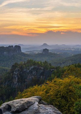 Almanya 'daki Sakson İsviçre Ulusal Parkı' ndaki kayalık uçurumların üzerinde gün batımı manzarası. Nefes kesici dağ manzarası, seyahat yeri, doğa güzelliği, dramatik akşam ışığı..