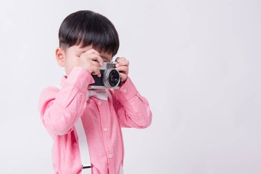 Kamera gömlek pembe beyaz arka plan üzerinde tutan çocuk