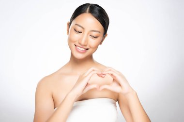 Güzel genç Asyalı kadın beyaz backgrou kalp el işareti yapmak