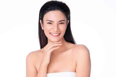 Güzel, genç Asyalı bir kadın yumuşak yanak gülümsemesine dokunuyor. Temiz ve taze tenli. Mutluluk ve neşe dolu.,