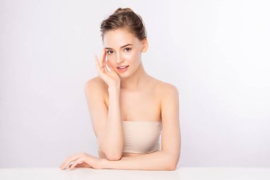 Güzel, genç bir kadın temiz yüzüne dokunuyor. Sağlıklı cilt, beyaz arka planda izole edilmiş güzellik kozmetik ve yüz bakımı konsepti.