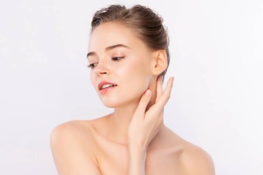 Güzel, genç bir kadın temiz yüzüne dokunuyor. Sağlıklı cilt, beyaz arka planda izole edilmiş güzellik kozmetik ve yüz bakımı konsepti.