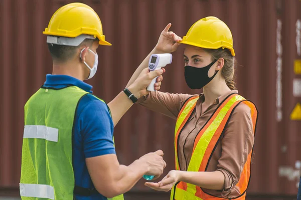 Pekerja Waring Bedah Masker Memeriksa Suhu Tubuh Menggunakan Termometer Digital Stok Foto Bebas Royalti