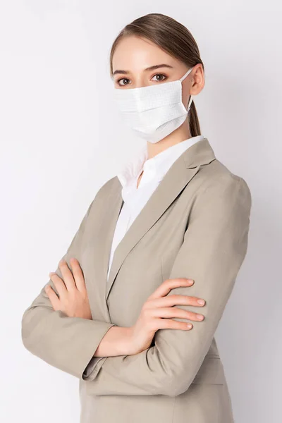 Business woman wears light brown suit and  mask standing on white background