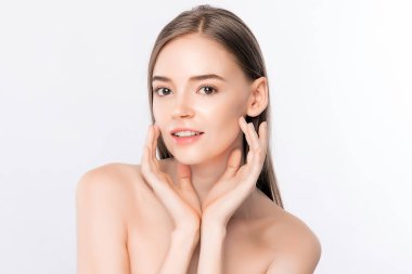 Güzel, genç bir kadın temiz yüzüne dokunuyor. Sağlıklı cilt, beyaz arka planda izole edilmiş güzellik kozmetik ve yüz bakımı konsepti..