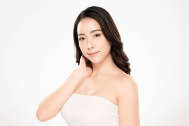 Güzel, genç Asyalı bir kadın vücuduna yeni sağlıklı bir ciltle dokunuyor, beyaz arka planda izole edilmiş, güzellik estetiği ve yüz bakımı konsepti.