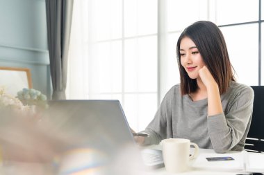 Asian working woman is working on her labtop. Working from home.