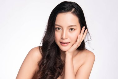 Güzel, genç Asyalı bir kadın temiz yüzüne yeni sağlıklı bir ciltle dokunuyor, beyaz arka planda izole edilmiş, Güzellik Kozmetik ve Yüz Bakımı Konsepti,