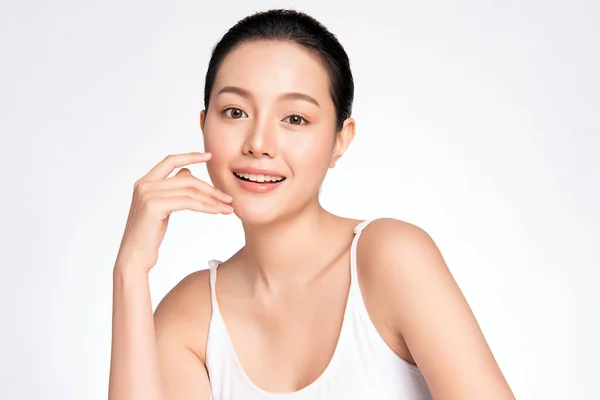 Güzel, genç Asyalı bir kadın temiz yüzüne yeni sağlıklı bir ciltle dokunuyor, beyaz arka planda izole edilmiş, Güzellik Kozmetik ve Yüz Bakımı Konsepti,