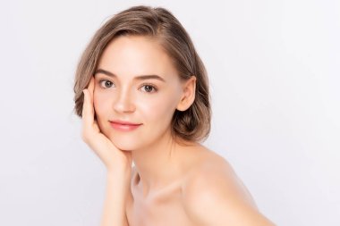 Güzel, genç bir kadın temiz yüzüne dokunuyor. Sağlıklı cilt, beyaz arka planda izole edilmiş güzellik kozmetik ve yüz bakımı konsepti.,