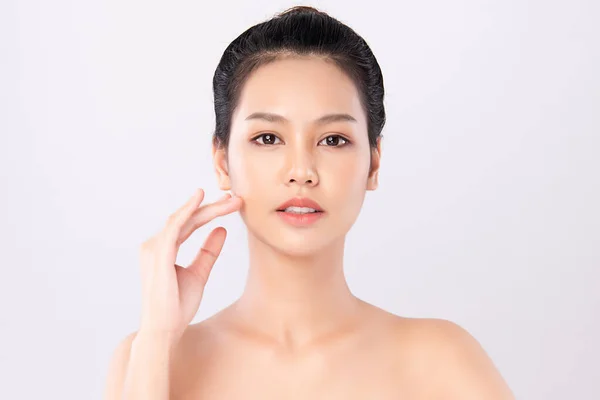 아름다운 아시아인 여인이 얼굴에 피부를 만지며 배경에 고립되어 화장품과 — 스톡 사진