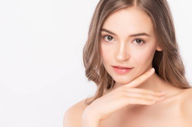 Güzellik Surat 'ı kapatın. Gülümseyen Asyalı kadın sağlıklı deri portresine dokunuyor. Güzel, mutlu bir kız modeli. Taze, nemli bir cildi ve beyaz arka planda doğal makyajı var.,