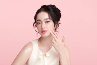 Pembe arka planda, temiz ve taze bir teni olan güzel bir Asyalı kadın. Cilt bakımı, yüz bakımı, kozmetoloji, güzellik ve kaplıca. Asyalı bir kadının zarif bir portresi..