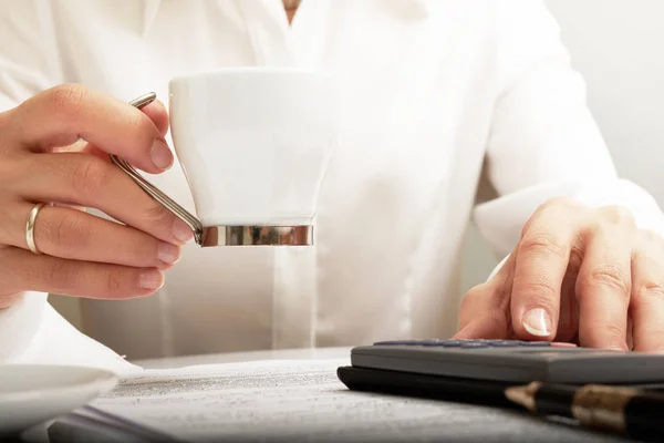 Mujer trabajando con documentos con una taza de café — Foto de Stock