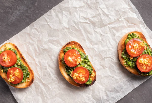 Sandwiches on toasted white bread with spinach cheese decorated with tomato slices. Shoot from above.
