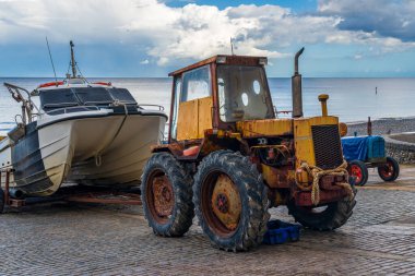 Denizden bir balıkçı teknesi getirdikten sonra traktör bir plaj rampasına park etmiş.