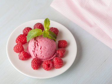 Hafif bir arka plan üzerinde bir ahududu dondurmalı çilek ve nane yaprakları