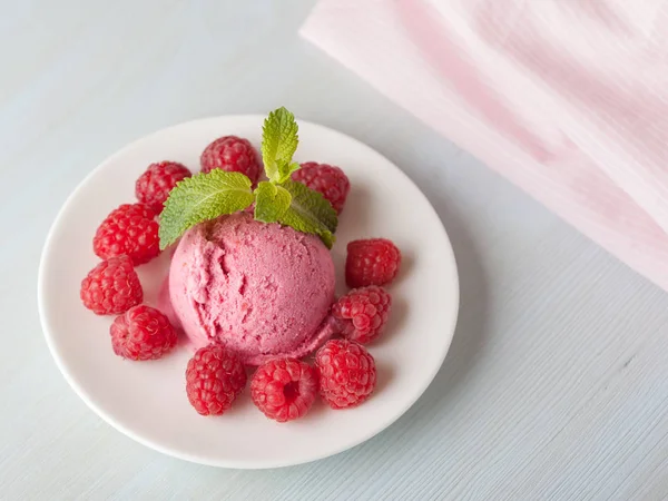 Hafif bir arka plan üzerinde bir ahududu dondurmalı çilek ve nane yaprakları